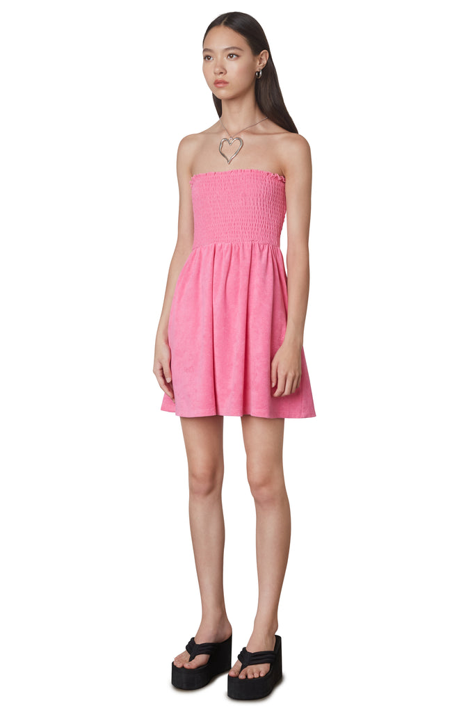 Smocked Terry Dress in Pink: Terrycloth mini strapless dress featuring a smocked bust and hidden pockets. Unlined. Side view.