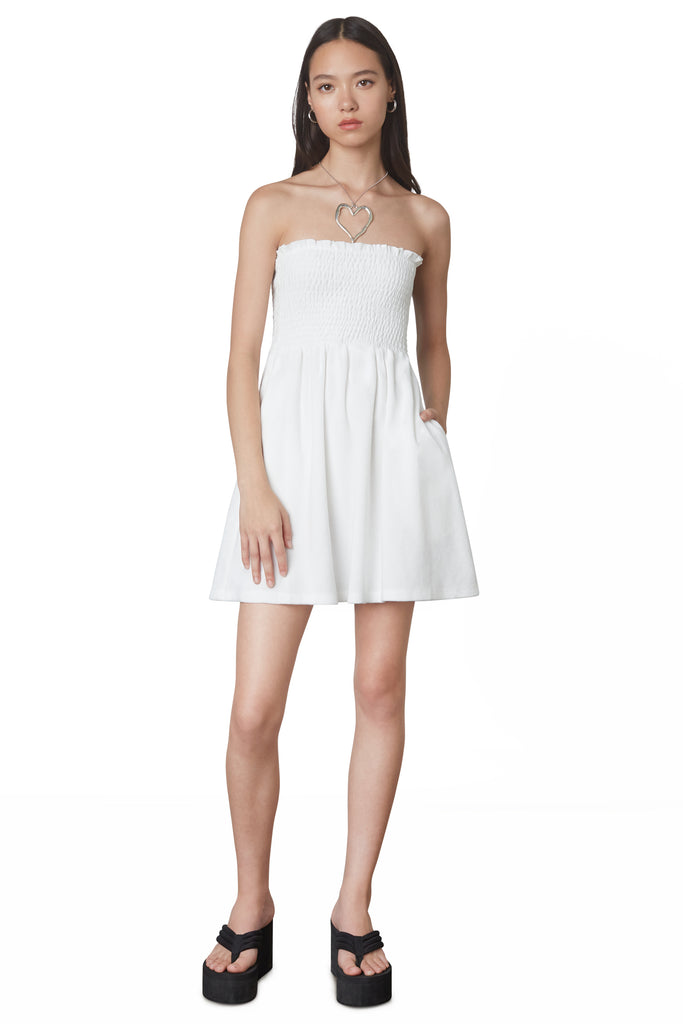 Smocked Terry Dress in White: Terrycloth mini strapless dress featuring a smocked bust and hidden pockets. Unlined. Front view 2.