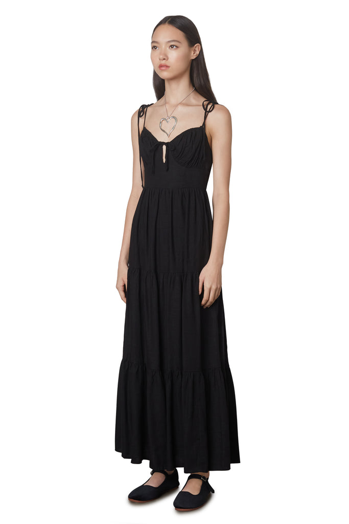 Aimee Dress in Black: Linen blend maxi dress festering a tiered skirt, self tie straps, and back zipper closure. Side view