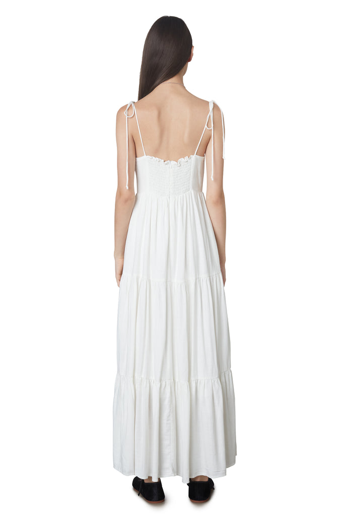 Aimee Dress in White: Linen blend maxi dress festering a tiered skirt, self tie straps, and back zipper closure. Back view