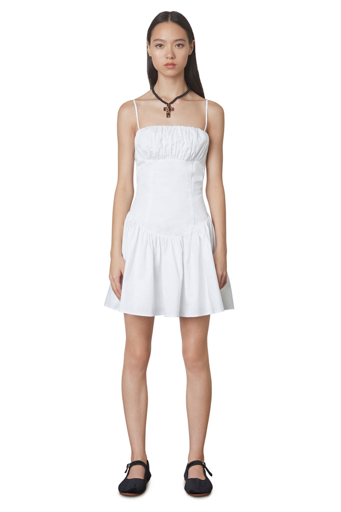 Puglia Dress in white: Poplin drop waist corset mini dress featuring a ruching detail at bust. Fully lined. front view