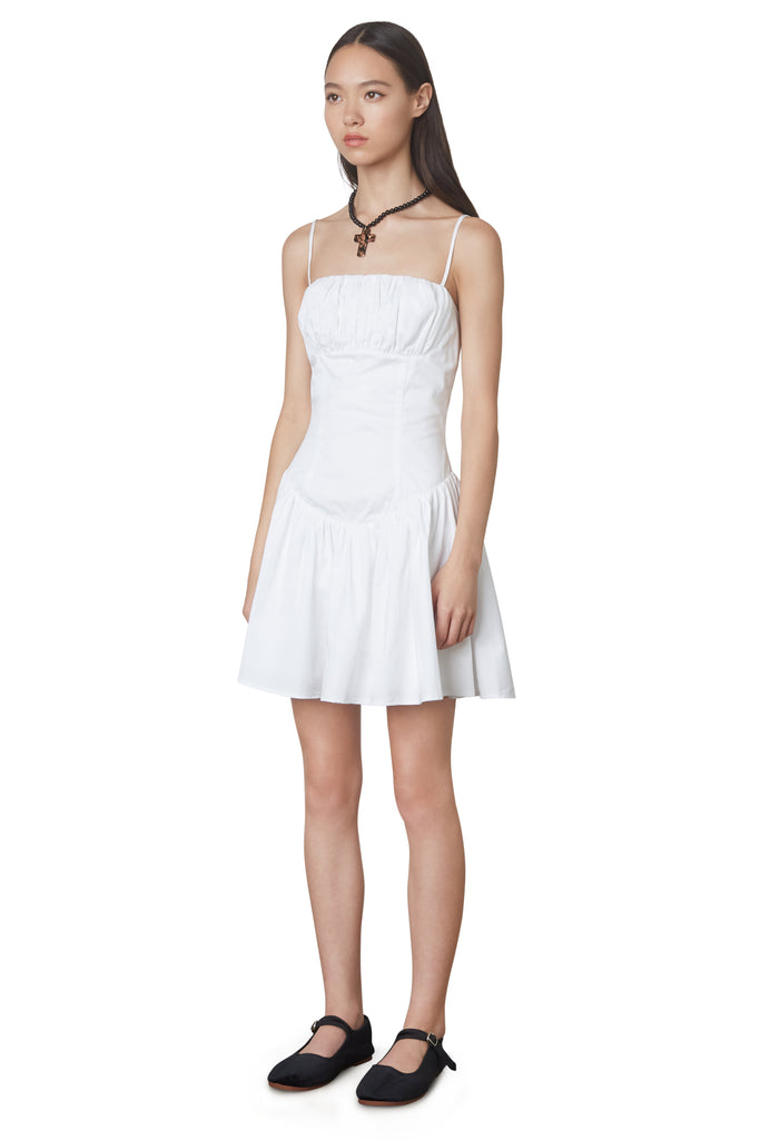 Puglia Dress in white: Poplin drop waist corset mini dress featuring a ruching detail at bust. Fully lined. side view