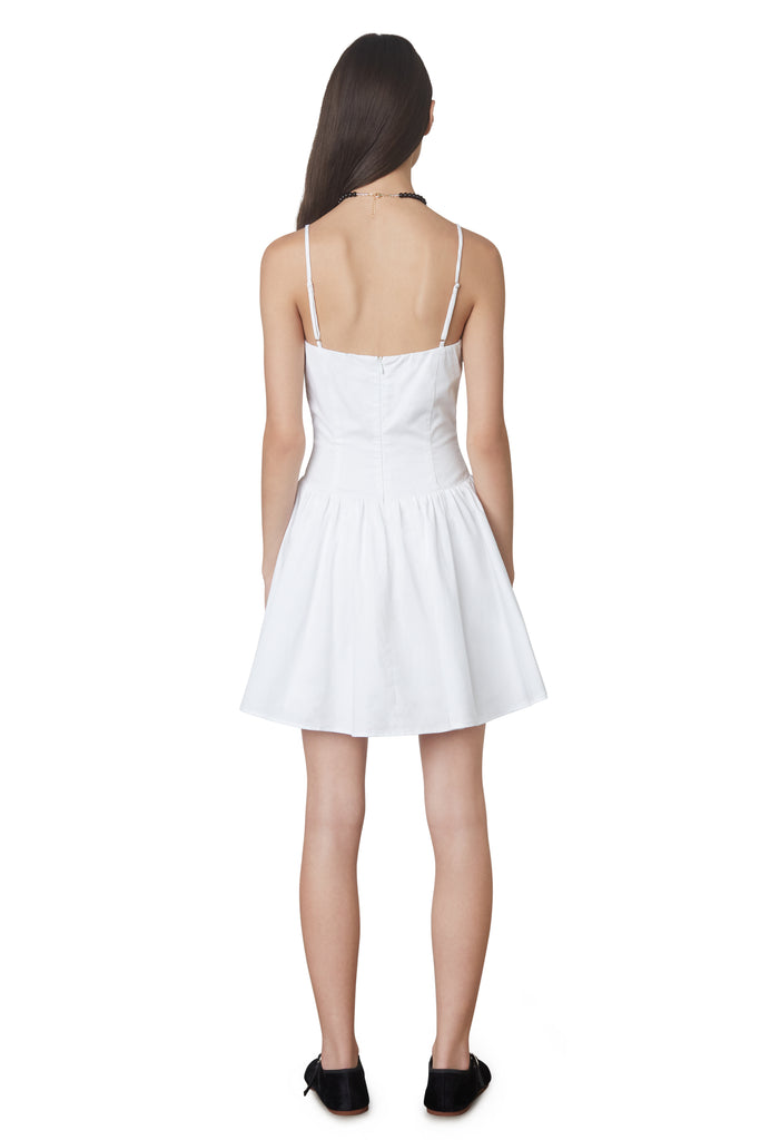 Puglia Dress in white: Poplin drop waist corset mini dress featuring a ruching detail at bust. Fully lined. back view