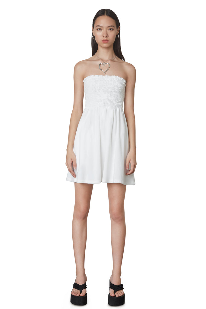 Smocked Terry Dress in White: Terrycloth mini strapless dress featuring a smocked bust and hidden pockets. Unlined. Front view.