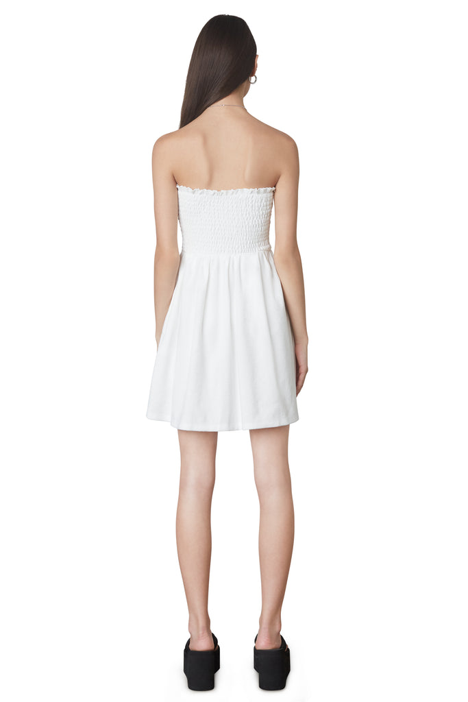 Smocked Terry Dress in White: Terrycloth mini strapless dress featuring a smocked bust and hidden pockets. Unlined. Back view.