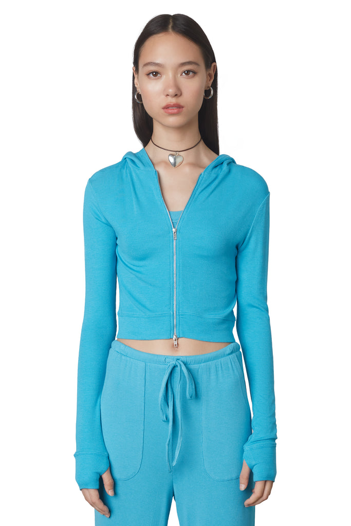Cropped Hacci Hoodie in Capri: Form fitting cropped ribbed zip up hoodie with double zipper detail and thumb holes. Front view.