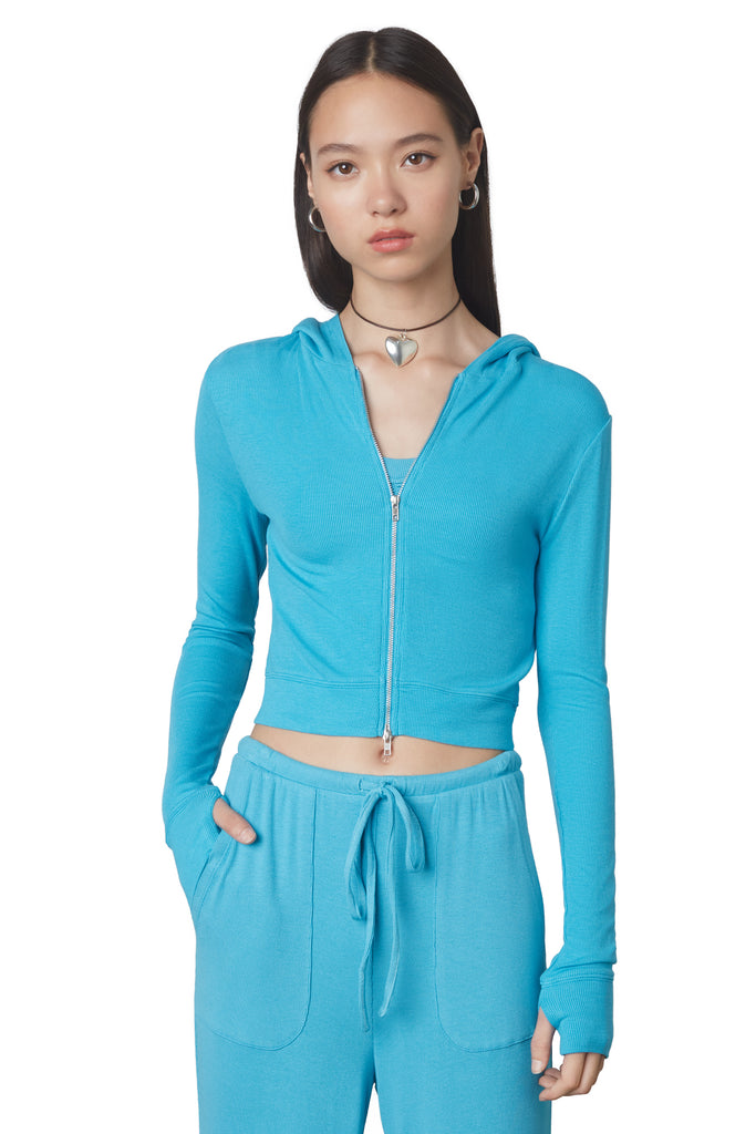 Cropped Hacci Hoodie in Capri: Form fitting cropped ribbed zip up hoodie with double zipper detail and thumb holes. Front view 2.