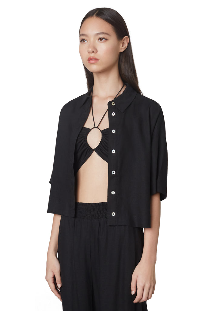 cropped boxy shirt in black: Cropped linen boxy shirt featuring shell buttons side view